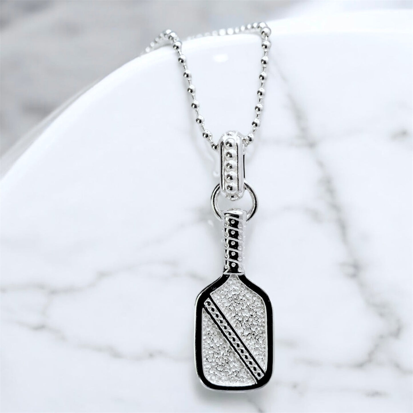 volli pickleball paddle necklace, sterling silver, bead chain on marble backdrop