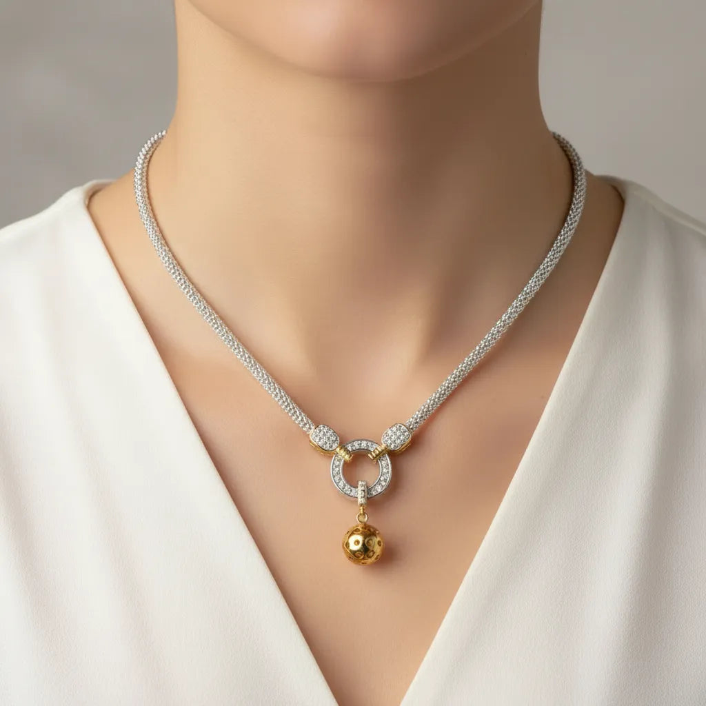 woman shown wearing white shirt and a beautiful silver and gold pickleball paddle and ball necklace with light gray background.