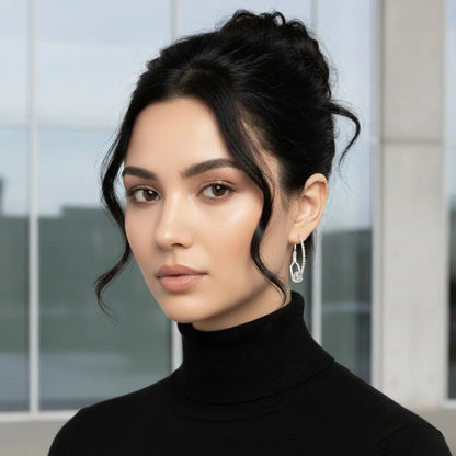 Woman wearing a black turtleneck and silver earring with a blurred background