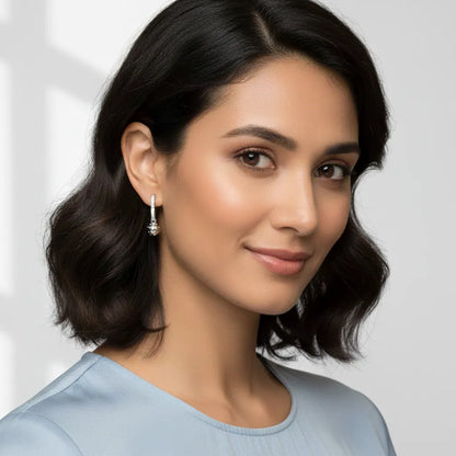 Woman wearing silver earrings with a plain background