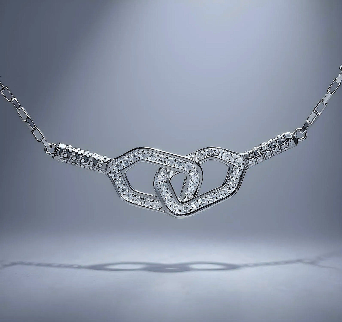 Silver necklace with double pickleball paddles pendant on a gray background