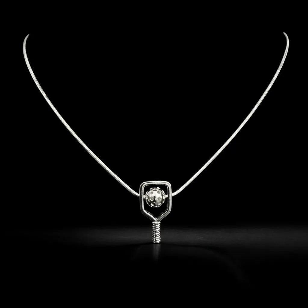 Silver pickleball necklace with a paddle and ball pendant on a black background